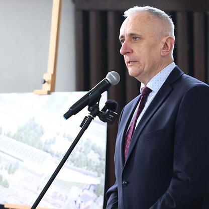 Wicemarszałek Leszek Pietraszek przemawia na podium podczas uroczystości dotyczącej transformacji terenu Bojków w Gliwicach, związanych z rozwinięciem infrastruktury kolejowej dla Kolei Śląskich. (wygenerowano przez AI)