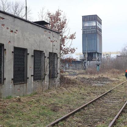 Abandoned industrial site with decaying buildings and overgrown vegetation, symbolizing transition from industrial use to a new, sustainable urban space. (wygenerowano przez AI)