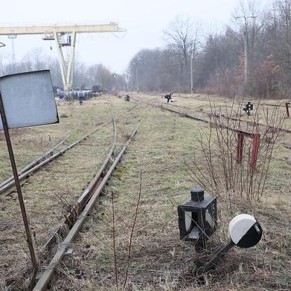 Abandoned railway yard with rusted tracks and scattered debris, hinting at a site once active but now in disrepair. (wygenerowano przez AI)