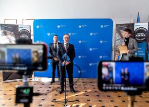 Wicemarszałek Województwa Śląskiego Grzegorz Boski i wiceprezes Kolei Śląskich Tomasz Niedziela prezentują nową ofertę dla dzieci i młodzieży podczas konferencji prasowej. (wygenerowano przez AI)