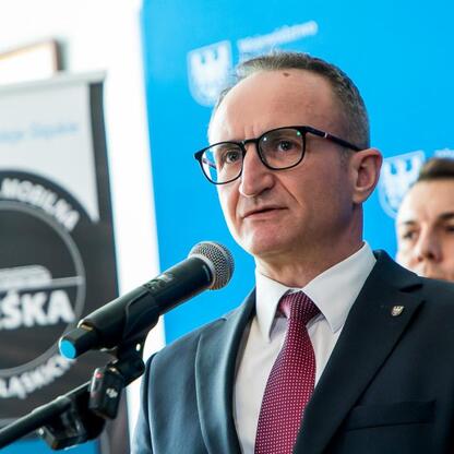 Wicemarszałek Województwa Śląskiego Grzegorz Boski prezentuje ofertę Kolei Śląskich na konferencji prasowej. (wygenerowano przez AI)