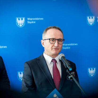 Grzegorz Boski, wicemarszałek Województwa Śląskiego, przemawia na konferencji prasowej o promocji biletów dla dzieci i młodzieży. (wygenerowano przez AI)
