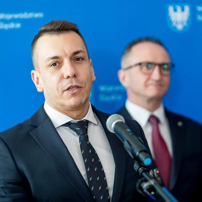 Grzegorz Boski, wicemarszałek Województwa Śląskiego, prowadzi konferencję prasową o promocji podróży pociągiem podczas ferii szkolnych. (wygenerowano przez AI)