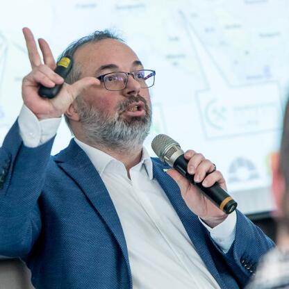 Przedstawiciel Rady ds. Sprawiedliwej Transformacji Województwa Śląskiego prowadzi prezentację na IV posiedzeniu w Dąbrowie Górniczej. (wygenerowano przez AI)