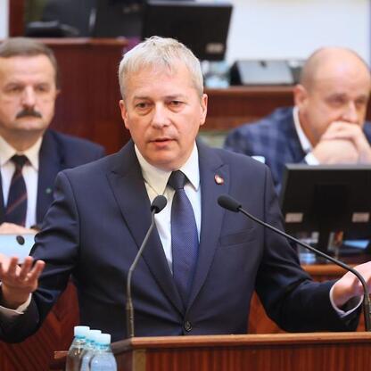 Wojciech Saługa, Marszałek Województwa Śląskiego, przemawia na podium podczas sesji Sejmiku Województwa Śląskiego. (wygenerowano przez AI)
