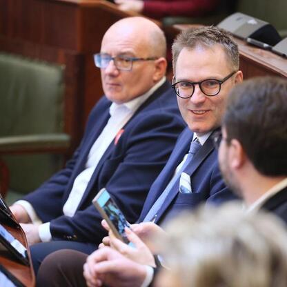 Formalna sesja Sejmiku Śląskiego, gdzie radni omawiają finanse i infrastrukturę regionu. (wygenerowano przez AI)