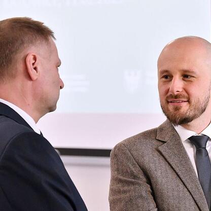 Dwa mężczyźni w strojach formalnych omawiają strategie adaptacji do zmian klimatu w Silesia. (wygenerowano przez AI)
