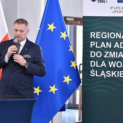 Rafał Adamczyk, członek Zarządu Województwa Śląskiego, przemawia na podium podczas briefingu o Regionalnym Planie Adaptacji do Zmian Klimatu. (wygenerowano przez AI)
