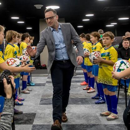 Widoczna jest konferencja prasowa przed meczem Ronaldinho Show, gdzie piłkarze i dziennikarze omawiają wydarzenie na Stadionie Śląskim. (wygenerowano przez AI)