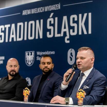 Stadion Śląski, konferencja prasowa, Rafał Adamczyk, Członek Zarządu Województwa Śląskiego, przygotowanie do meczu z Ronaldinho i byłymi piłkarzami Brazilii. (wygenerowano przez AI)