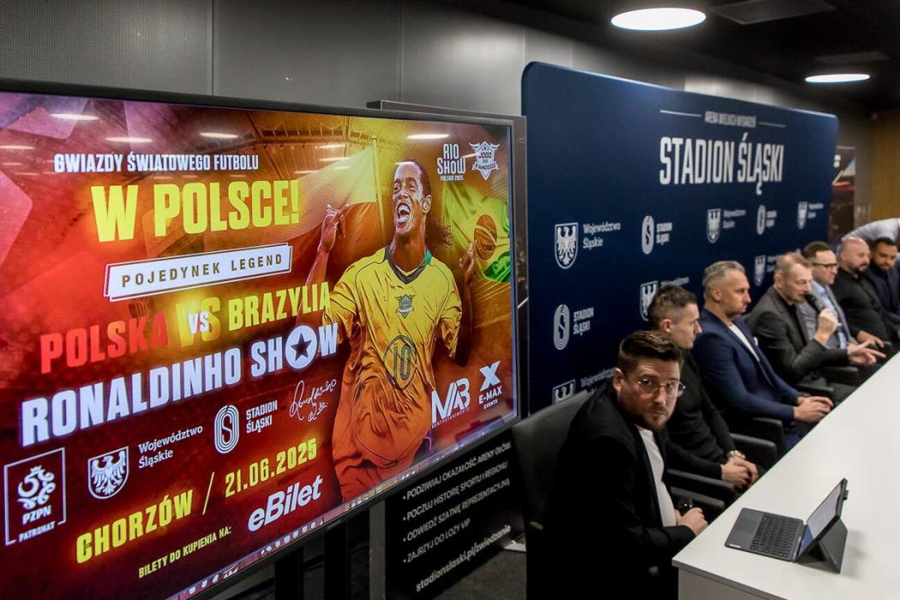 Konferencja prasowa przed meczem Ronaldinho Show na Stadionie Śląskim, gdzie Rafał Adamczyk omawia znaczenie wydarzenia. (wygenerowano przez AI)