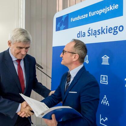 Grzegorz Boski, Wicemarszałek Województwa Śląskiego, wręcza gratulacje przedstawicielom gmin w ramach programu Fundusze Europejskie dla Śląska 2021-2027. (wygenerowano przez AI)