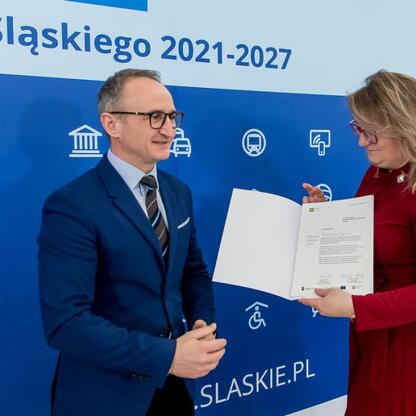 Wicemarszałek Grzegorz Boski wręcza dokumenty przedstawicielom gmin w ramach programu Fundusze Europejskie dla Śląska 2021-2027. (wygenerowano przez AI)