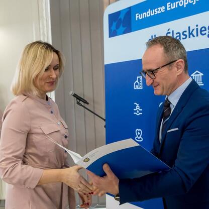 Wicemarszałek Grzegorz Boski wręcza listy gratulacyjne przedstawicielom gmin. (wygenerowano przez AI)