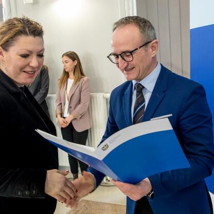 Wicemarszałek Grzegorz Boski wręcza dokumenty na konferencji kultury, turystyki i edukacji województwa śląskiego. (wygenerowano przez AI)