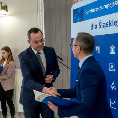 Grzegorz Boski wręcza gratulacje lokalnym władzom w ramach projektu Funduszy Europejskich dla Śląska 2021-2027. (wygenerowano przez AI)