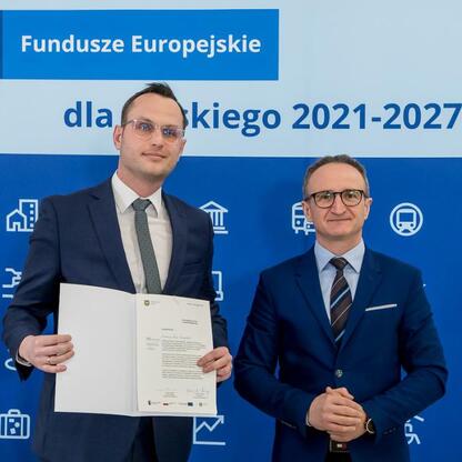 Wicemarszałek Grzegorz Boski wręcza gratulacje przedstawicielom gmin w ramach programu Funduszy Europejskich dla Śląska 2021-2027. (wygenerowano przez AI)