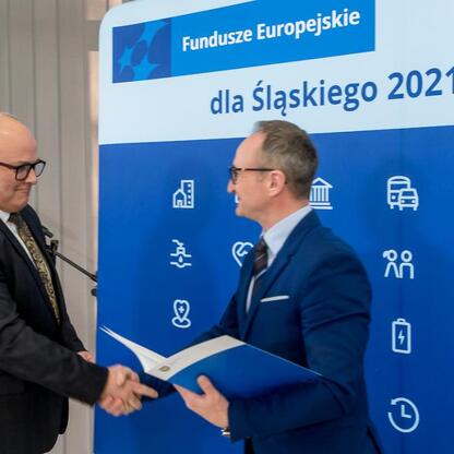Grzegorz Boski, Wicemarszałek Województwa Śląskiego, wręcza listy gratulacyjne przedstawicielom gmin w ramach programu Funduszy Europejskich dla Śląska 2021-2027. (wygenerowano przez AI)