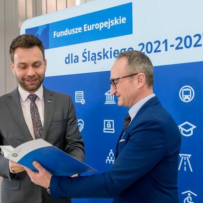 Wicemarszałek Grzegorz Boski wręcza folder przedstawicielom gmin, promując projekty kultury, turystyki i edukacji zawodowej. (wygenerowano przez AI)