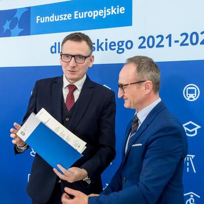 Grzegorz Boski wręcza dokument Marcinowi Ryśowi, podkreślając wspólne cele rozwoju kultury i turystyki w regionie Śląskim. (wygenerowano przez AI)
