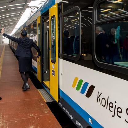 Pociąg Impuls 2 odjeżdża z Katowic do Bohumina, operator wita pasażera. (wygenerowano przez AI)