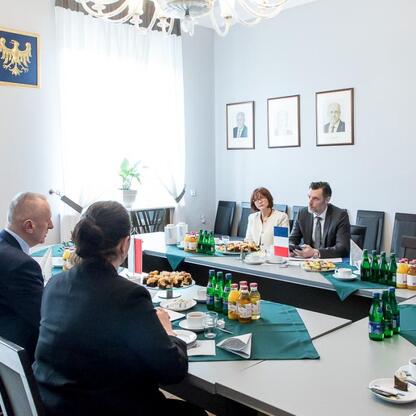 Leszek Pietraszek, Wicemarszałek Śląska, i Cédric Peltier, Konsul Generalny Francji w Krakowie, uczestniczą w formalnym spotkaniu w konferencyjnym pomieszczeniu. (wygenerowano przez AI)