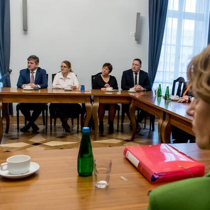 Formalna sesja w konferencyjnym pomieszczeniu, gdzie rozmawiają o finansowaniu inwestycji w infrastrukturę lokalną w regionie Śląskim. (wygenerowano przez AI)