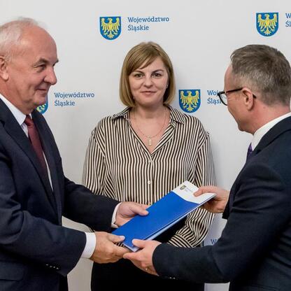 Grzegorz Boski prezentuje umowy finansowe dla gmin Śląska. (wygenerowano przez AI)