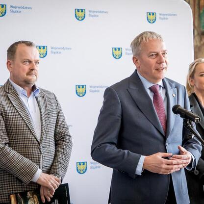Wojciech Saługa, Arkadiusz Chęciński i Anna Jedynak-Rykała omawiają metamorfozę byłej kopalni KWK Kazimierz – Juliusz w Sosnowcu. (wygenerowano przez AI)