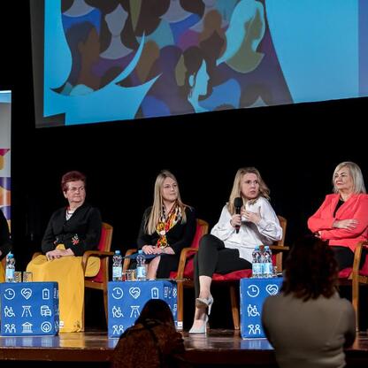 Panel dyskusyjny z udziałem przedstawicieli administracji województwa śląskiego podczas konferencji o współpracy pokoleniowej w kinoteatrze Rialto. (wygenerowano przez AI)