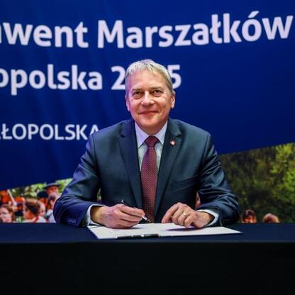 Marszałek Województwa Małopolska Wojciech Saługa podpisuje dokument na Konwencie Marszałków Województw Małopolska 2025. (wygenerowano przez AI)