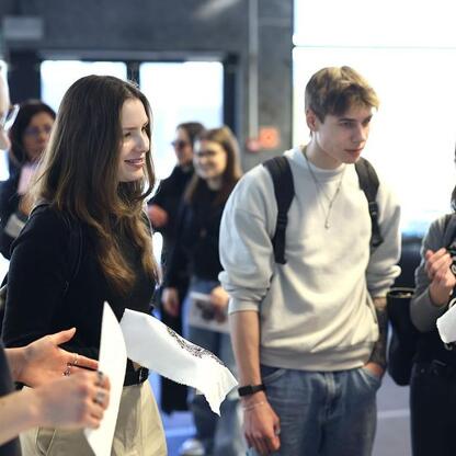Grupa młodych ludzi dyskutuje podczas EduPromoDay, prezentując informacje o edukacji wyższej. (wygenerowano przez AI)