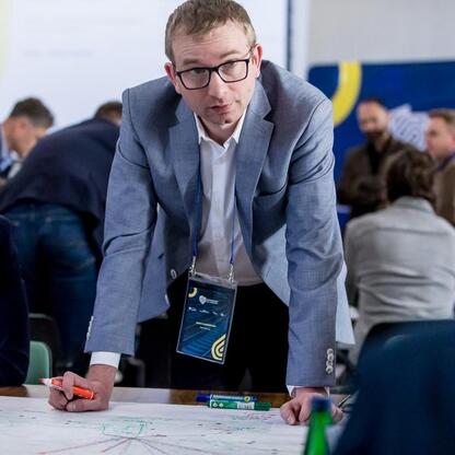 W trakcie warsztatów wojewódzkich w Urzędzie Marszałkowskim Województwa Śląskiego przedstawiciel tego regionu, wicemarszałek Grzegorz Boski, omawia z uczestnikami strategię rozwoju Zintegrowanej Sieci (wygenerowano przez AI)