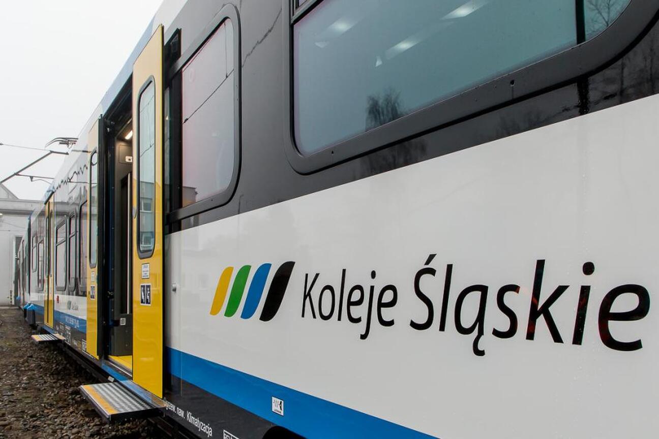 Zaokrąglony logo "Koleje Śląskie" na białym tle z niebieskimi i żółtymi akcentami. (wygenerowano przez AI)