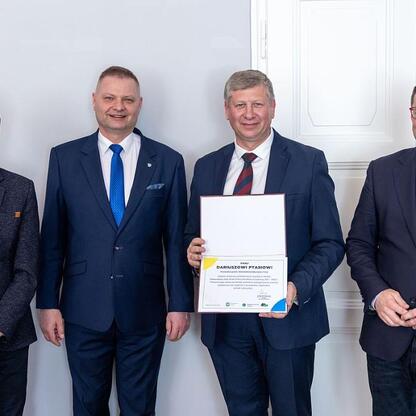 Członek Zarządu Województwa Rafał Adamczyk odbiera certyfikat, podczas obrad Wojewódzkiej Rady Rynku Pracy. (wygenerowano przez AI)