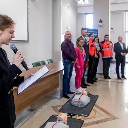 Rafał Adamczyk, członek Zarządu Województwa Śląskiego, przemawia podczas finału konkursu wiedzy o pierwszej pomocy. (wygenerowano przez AI)