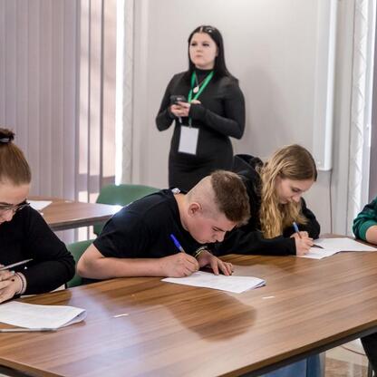 Wojewódzki konkurs wiedzy o pierwszej pomocy, uczestnicy zapisują się w testach. (wygenerowano przez AI)