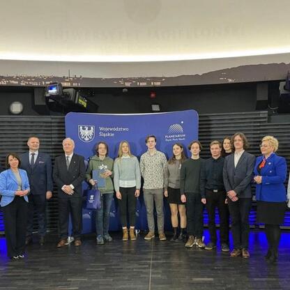 Grupa uczestników 68. Olimpiady Astronomicznej przed Planetarium Śląskim Parku Nauki. (wygenerowano przez AI)