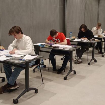 Grupa studentów koncentruje się na zadaniach w planetarium, podczas 68. Olimpiady Astronomicznej. (wygenerowano przez AI)