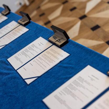 Na stole leżą dokumenty i pierścionek, symbolizujący porozumienie o współpracy w Silesia Education Congress. (wygenerowano przez AI)