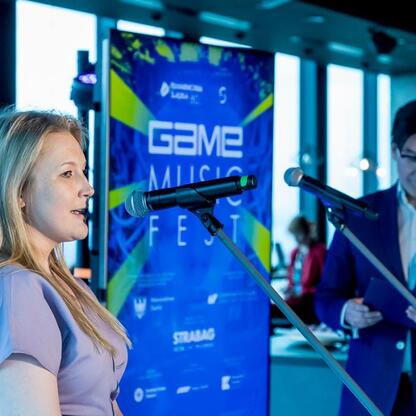 Joanna Bojczuk, członek Zarządu Województwa Śląskiego, przemawia na konferencji prasowej Game Music Fest. (wygenerowano przez AI)