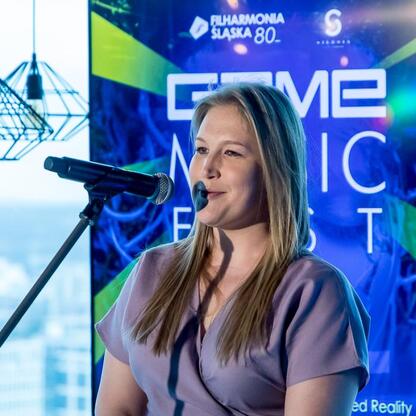 Joanna Bojczuk, członek Zarządu Województwa Śląskiego, przemawia na konferencji prasowej Game Music Fest. (wygenerowano przez AI)