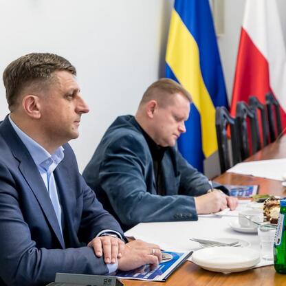 Diplomacy in action: Two men in business attire discuss modernizing railway lines and constructing new stations in Gliwice, Śląsk. (wygenerowano przez AI)