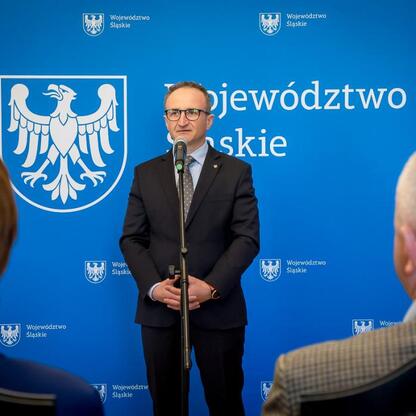 Wicemarszałek Grzegorz Boski przemawia na ceremonii wręczenia listów gratulacyjnych w Gmachu Sejmu Śląskiego. (wygenerowano przez AI)