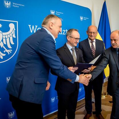 Wicemarszałek Grzegorz Boski wręcza listy gratulacyjne przedstawicielom otrzymania dofinansowania dla inwestycji w gospodarkę wodno-ściekową w gminach Śląska. (wygenerowano przez AI)