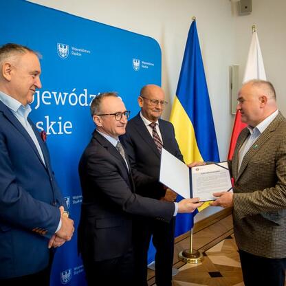 Wicemarszałek Grzegorz Boski wręcza certyfikaty projektom zrównoważonej gospodarki wodno-ściekowej województwa śląskiego. (wygenerowano przez AI)