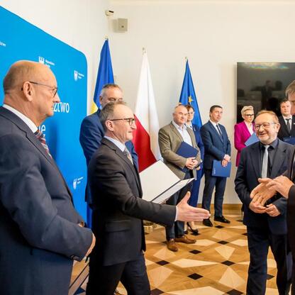Wicemarszałek Grzegorz Boski wręcza certyfikaty przedstawicielom lokalnych entitetów za inwestycje w gospodarkę wodno-ściekową. (wygenerowano przez AI)