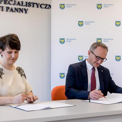 Grzegorz Boski i Beata Pochodnia podpisują dokumenty w Wojewódzkim Szpitalu Specjalistycznym im. Najświętszej Maryi Panny w Częstochowie. (wygenerowano przez AI)