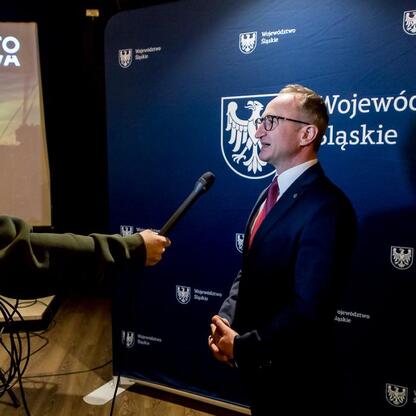 Wicemarszałek Województwa Śląskiego Grzegorz Boski przemawia na podium podczas spotkania organizacyjnego Jasnogórskiego Zlotu Rowerowego – CZEWA BIKE FEST. (wygenerowano przez AI)