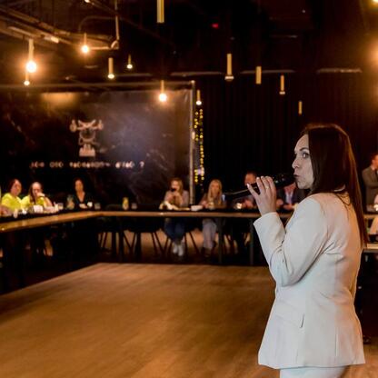 Na scenie w jasnogórskim ośrodku konferencyjnym stoi kobieta z mikrofonem, przemawia do zgromadzonej publiczności. (wygenerowano przez AI)